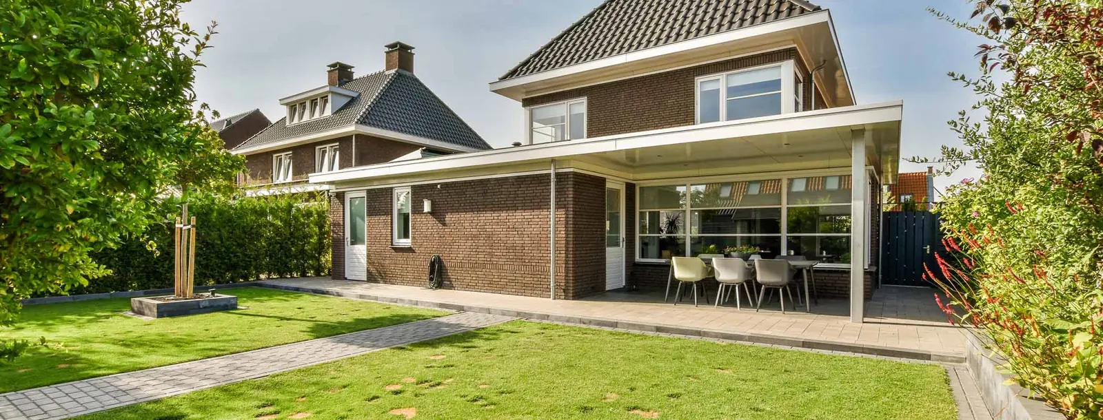 Woning met een glazen tuinkamer en een tuin met gazon