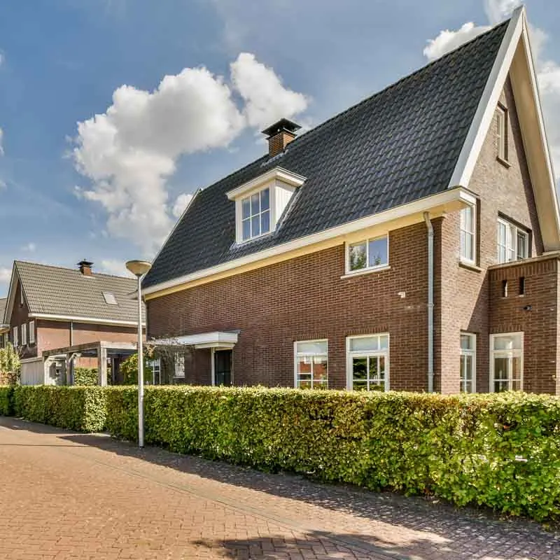 Vrijstaande bakstenen woning met witte kozijnen