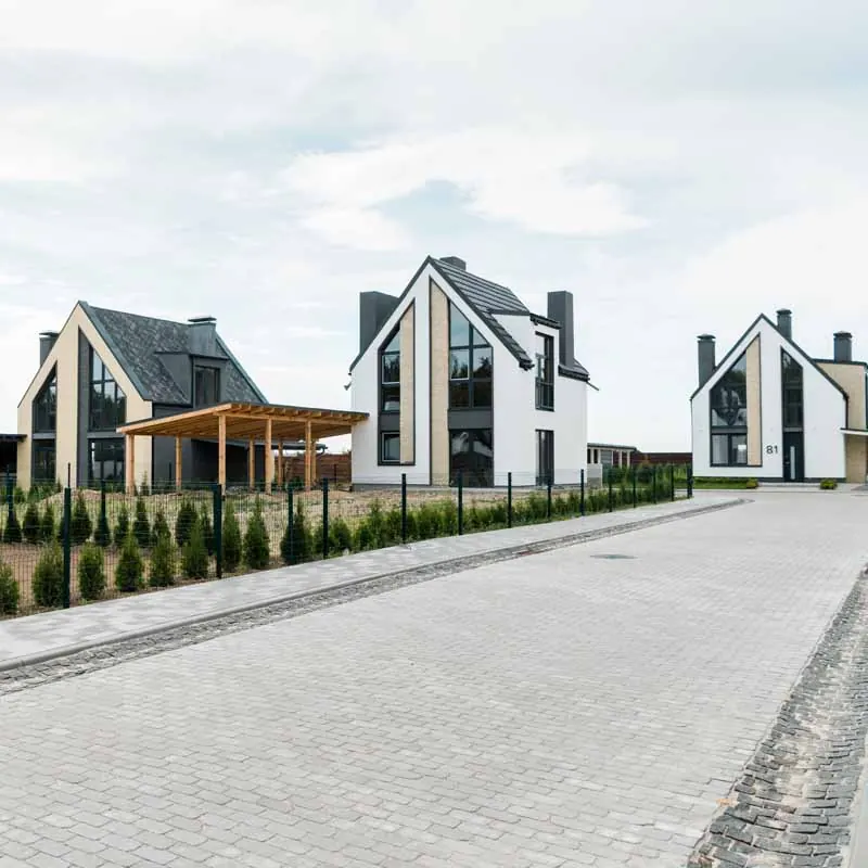 Nieuwbouwwoningen met puntdaken aan een geklinkerde straat